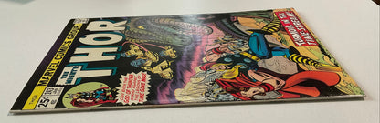 Comic book featuring Thor on a white surface with stacks of paper in the background