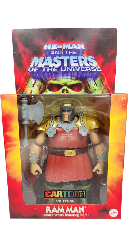 Toy figure in packaging with 'Masters of the Universe' branding on a dark surface.